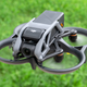 The DJI Avata drone hovering over grass.